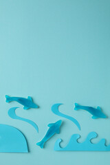 Gummy candies in the form of whale and decorative waves on blue background