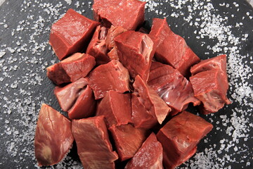 Raw sliced beef heart on black background. Top View 