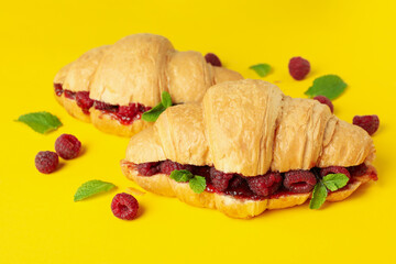 Croissants with raspberry jam on yellow background