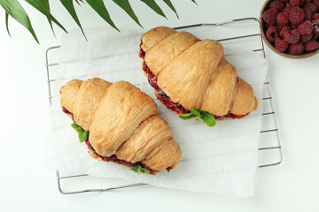 Concept of delicious food with croissants with raspberry jam on white background
