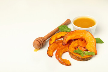 Baked pumpkin, mint, honey and dipper on white background