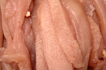 Photo of sliced ​​chicken meat on a dark cutting board with cut marks