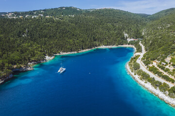 Panoramic aerial view of Foki Beach and sailing yacht boats moored in turquoise bay. Fiskardo, Kefalonia island, Greece