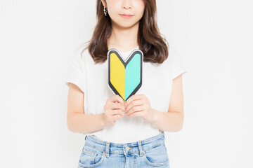 初心者マークを持っているTシャツを着た若い女性