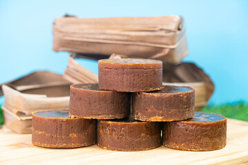 A stack of the palm sugar with dried coconut leaves used for packing. Selective focus points. Blurred background