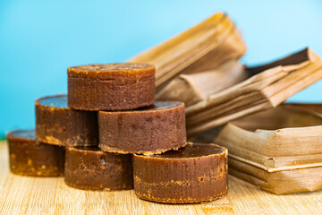 A stack of the palm sugar with dried coconut leaves used for packing. Selective focus points. Blurred background