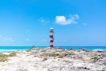 Lighthouse on rocky coastal shore of beautiful seascape against cloudy sky. Lighthouse on seashore