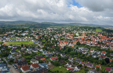 Aerial view of the center of the town of Horn in the Teutoburg Forest. In the middle is a school and on the right the town hall and the church. It's a cloudy summer day with some sunshine.