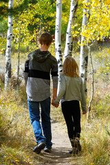 Boy and girl walking in woods holding hands