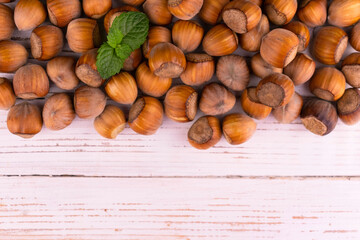 Hazelnuts on a white wooden background.
Copy space.