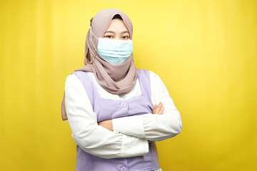 Muslim woman wearing medical mask, confident and excited, isolated on yellow background