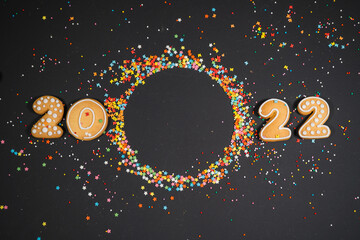 Christmas background with gingerbread 2022 on gray surface. Holiday mood card. Top view, copy...