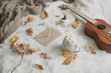 Fototapeta na wymiar Christmas flat lay at home with hot cocoa and marshmallows, knitted blanket and ukulele