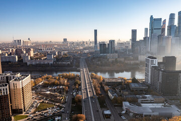 Obraz premium a panoramic view of the city business skyscrapers in the morning fog at sunrise filmed from a drone 