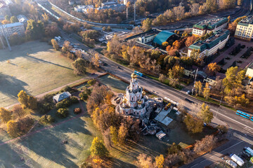 a panoramic view of a beautiful old church in the early morning at the crossroads filmed from a drone 