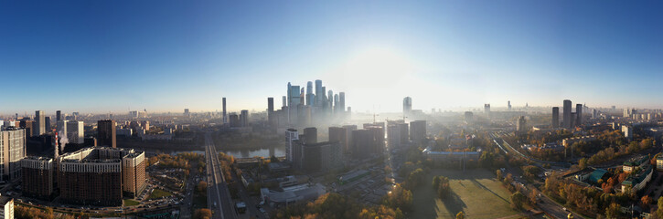 Fototapeta premium a panoramic view of the city business skyscrapers in the morning fog at sunrise filmed from a drone 