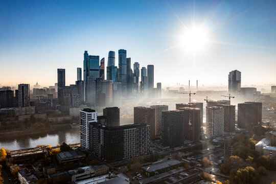 a panoramic view of the city business skyscrapers in the morning fog at sunrise filmed from a drone 