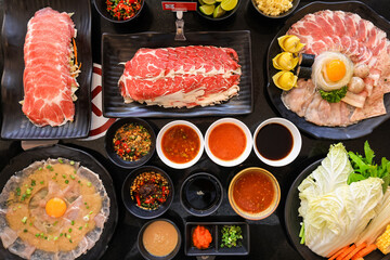 top view of beef and pork sliced with spicy sauce at shabu restaurant