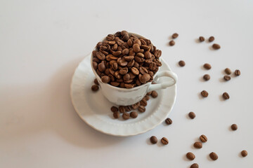 Coffee cup on white background and spilled coffee beans on white background.
world coffee day concept.
Turkish coffee concept.Selective focus.