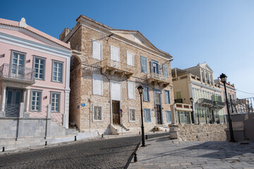 Naklejka premium Stonewall houses cobblestone street at Ermoupoli capital of Syros island, Cyclades, Greece.