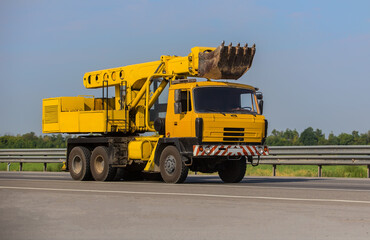 Truck Excavator Drives on Road