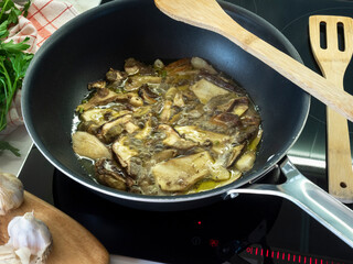 Freschi funghi porcini in padella su piano a induzione