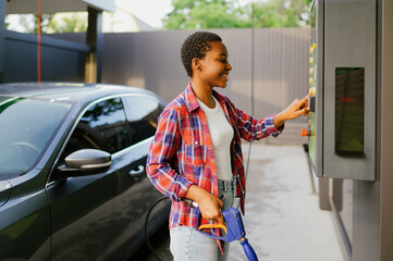 Obraz premium Woman choosing program on car wash station