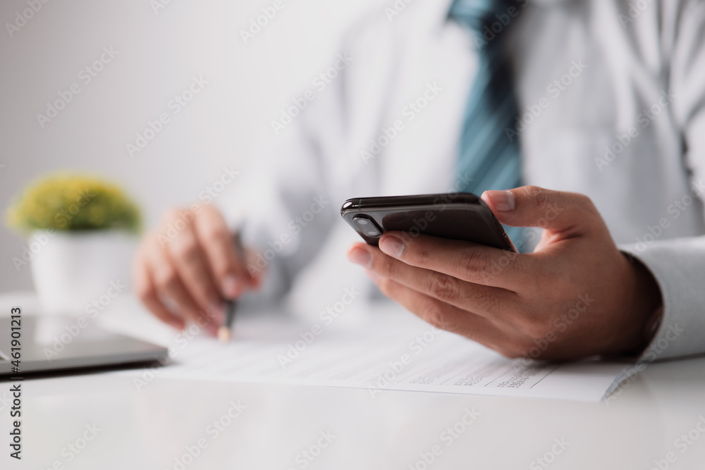 Poster Man editor is reading a document or report at work, while a financier is reading a contract agreement on paper and reviewing the newest financial news on a smartphone application.