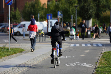 Młodzy mężczyzna jedzie na rowerze po ścieżce rowerowej we Wrocławiu.