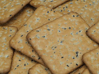 Many delicious crackers as background, top view