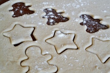 Fototapeta na wymiar Christmas cookie dough stretched and cut with gingerbread man and stars molds