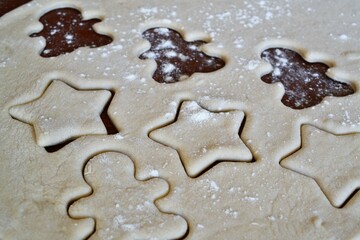 Christmas cookie dough stretched and cut with gingerbread man and stars molds