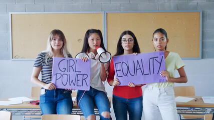 Girl students hold up a sign with the slogan: Girl power, equality 