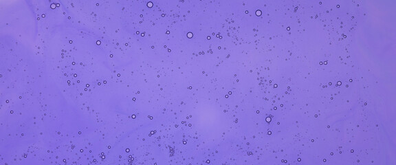 Abstract background, tiny air bubbles suspended in a thick purple liquid. Flat lay top view