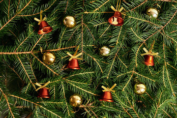 new year christmas background with fir branches, christmas tree, toys, golden balls, red bells