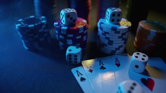 Casino chips with dice and playing cards on a dark table. Concept of gambling or poker and entertainment. Close up macro shoot. Online casino betting