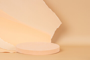 Abstract trendy composition with empty round podium platform for product presentation and curve shaped torn light brown paper edges on pastel beige background. Front view