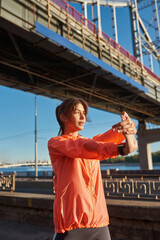 Active millennial woman stretching before outdoor workout