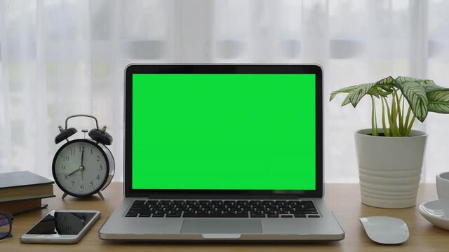 4K : A laptop computer with a key green screen set on work office table.
