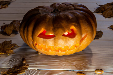 One Scary, evil-looking Halloween Jack Lantern surrounded by Autumn leaves,