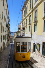 Naklejka na ściany i meble Vintage tram in the city center of Lisbon in a beautiful summer day, Portugal. Traditional yellow tram on a street in Lisbon, Portugal.