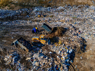 Garbage dump and working dump truck and bulldozer, aerial view
