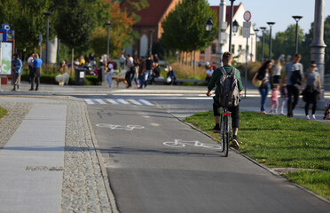 Młodzy mężczyzna jedzie na rowerze po ścieżce rowerowej we Wrocławiu. - obrazy, fototapety, plakaty