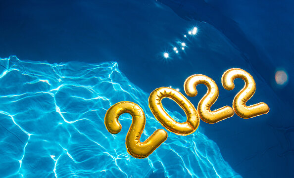 golden numbers 2022 float in the clear blue water of the pool.the concept of the new year at the sea