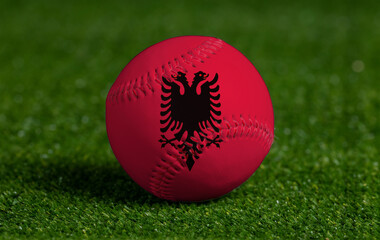 Baseball with Albania flag on green grass background, close up