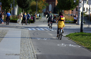 Młoda kobieta jedzie na rowerze po ścieżce rowerowej we Wrocławiu. - obrazy, fototapety, plakaty