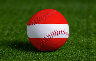 Baseball with Austria flag on green grass background, close up