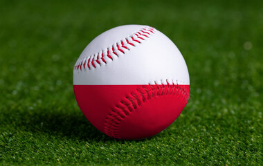 Baseball with Poland flag on green grass background, close up