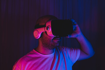 man wearing virtual glasses. in a room with blue and red lights. metaverse new concept new world.