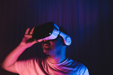 man wearing virtual glasses. in a room with blue and red lights. metaverse new concept new world.
